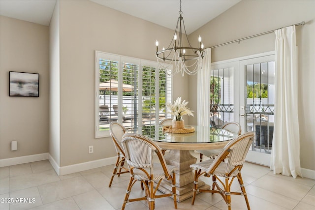 dining room with a chandelier, lofted ceiling, plenty of natural light, and light tile patterned floors