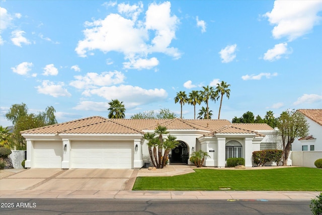 mediterranean / spanish home with an attached garage, a tiled roof, driveway, stucco siding, and a front lawn