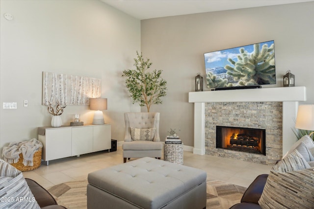 living room featuring a fireplace, baseboards, and light tile patterned floors