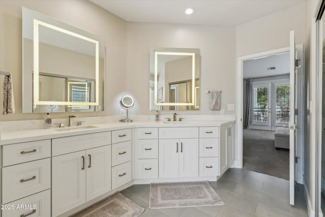 full bath featuring double vanity, tile patterned flooring, a sink, and recessed lighting