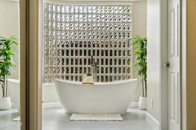 interior space featuring a freestanding bath and baseboards