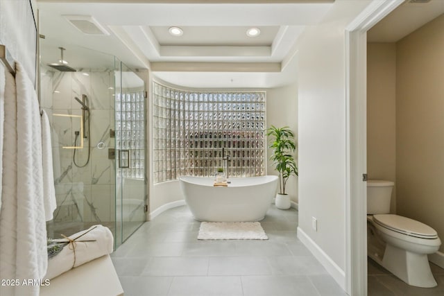 full bathroom featuring a tray ceiling, a marble finish shower, a soaking tub, visible vents, and toilet