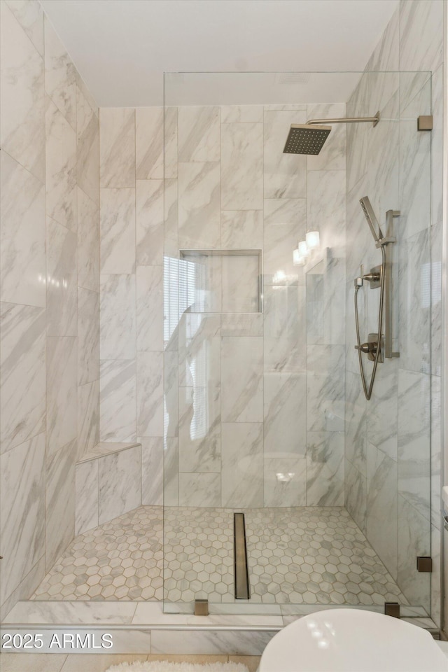 bathroom featuring a stall shower and toilet