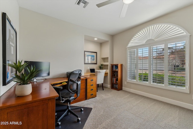 home office featuring light carpet, ceiling fan, visible vents, and baseboards