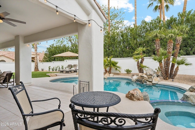 view of swimming pool with ceiling fan, a patio, a fenced backyard, and a pool with connected hot tub