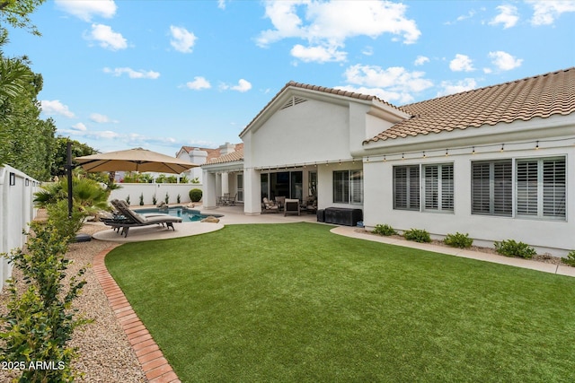 back of property with a fenced in pool, a lawn, a fenced backyard, a patio area, and stucco siding