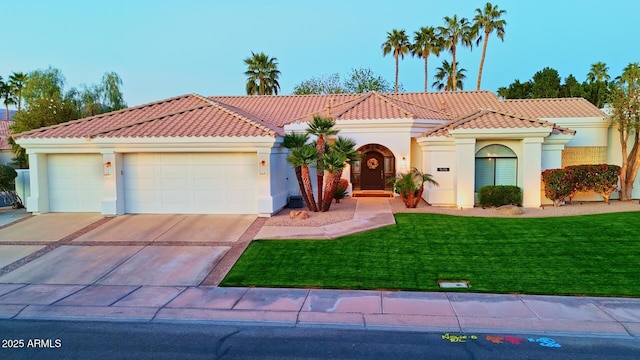 mediterranean / spanish home featuring a garage, concrete driveway, a tile roof, a front yard, and stucco siding