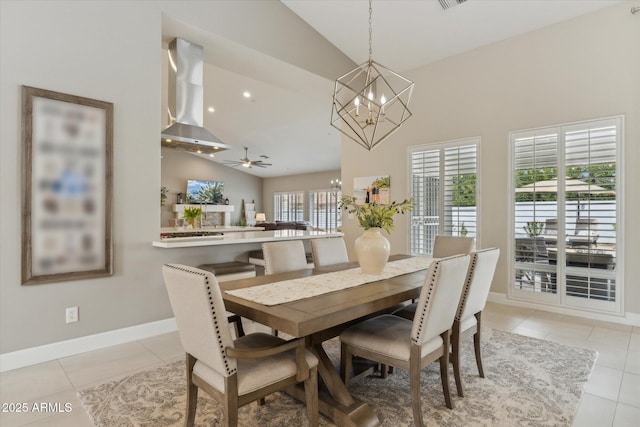 dining room featuring ceiling fan with notable chandelier, vaulted ceiling, baseboards, and light tile patterned floors