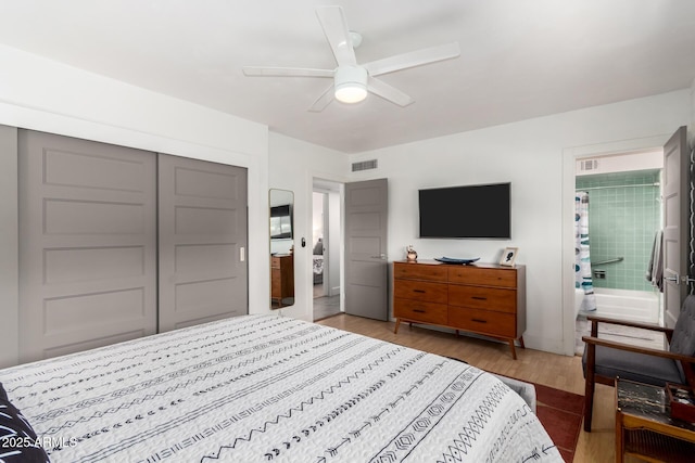 bedroom with a closet, wood finished floors, visible vents, and a ceiling fan