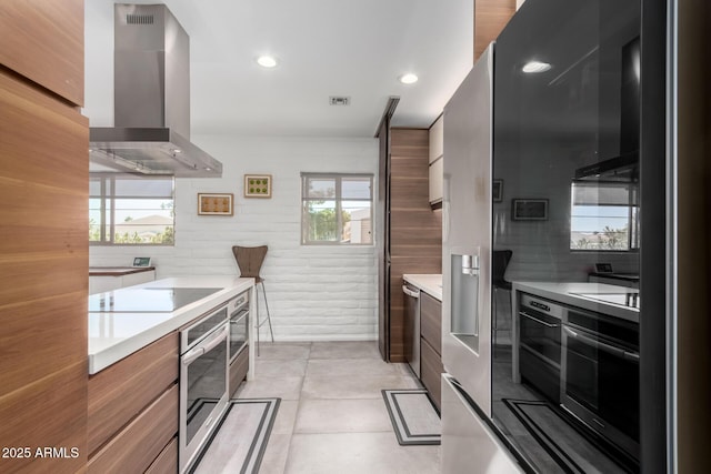 kitchen with wall chimney exhaust hood, electric stovetop, modern cabinets, and oven