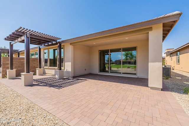 back of property with central AC unit, a pergola, and a patio