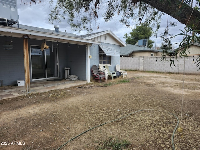 back of property featuring central air condition unit, a patio, concrete block siding, and fence