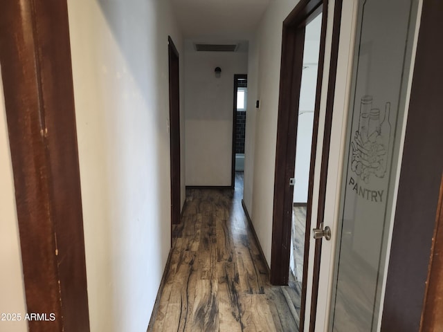 corridor with wood finished floors and visible vents