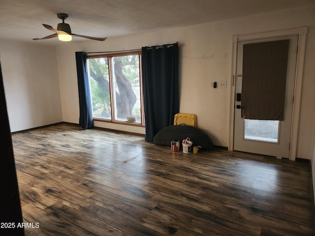 spare room featuring ceiling fan, baseboards, and wood finished floors