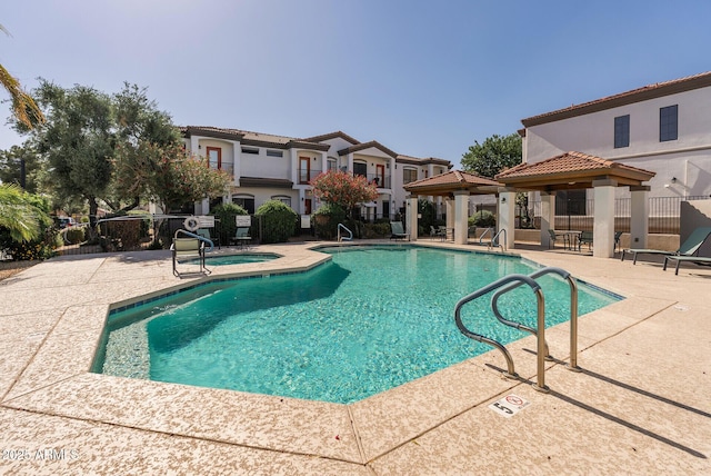 community pool featuring a gazebo, a hot tub, a patio, and fence