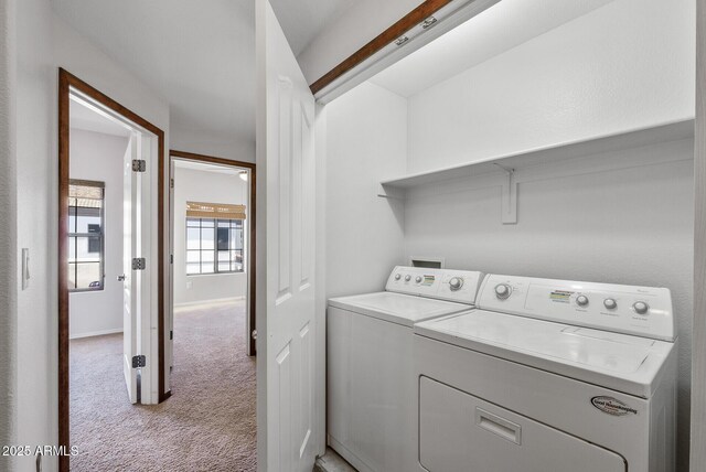 clothes washing area with light carpet and washer and dryer