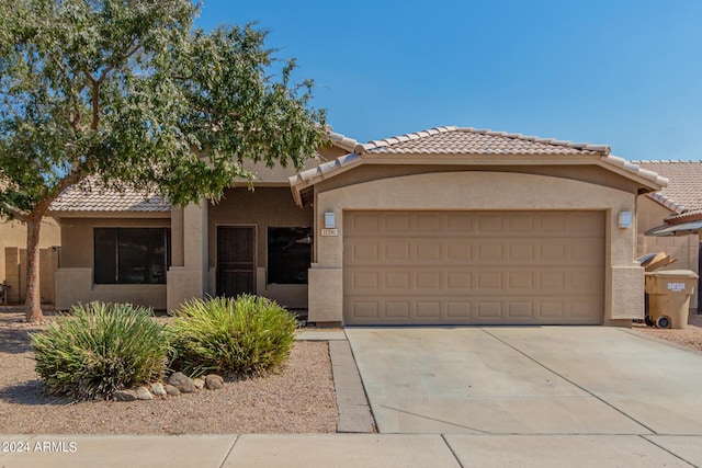 view of front of property featuring driveway, an attached garage, and stucco siding