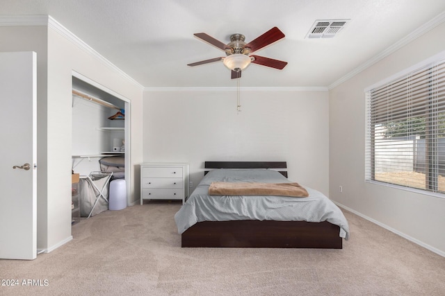 carpeted bedroom featuring baseboards, a ceiling fan, visible vents, and crown molding