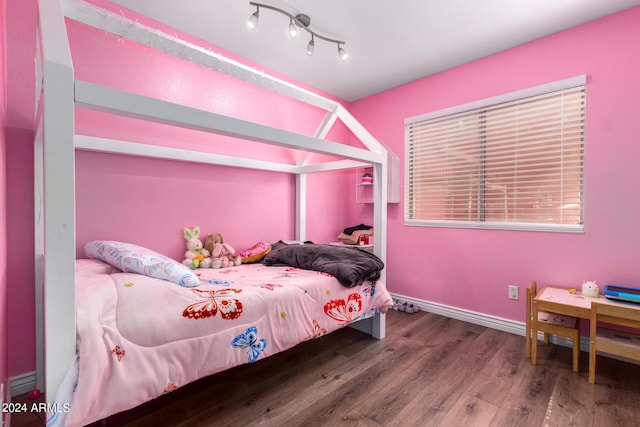 bedroom featuring baseboards and wood finished floors