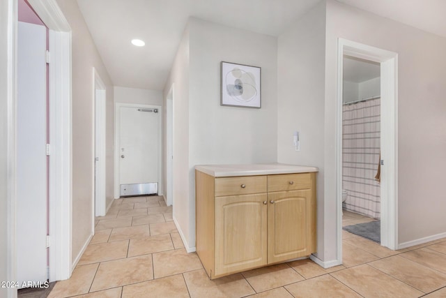 hallway with light tile patterned floors, recessed lighting, and baseboards