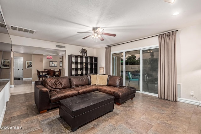 8219 E Morgan Trl, Scottsdale, AZ 85258 - living room with ceiling fan, stone finish floors, and a textured ceiling