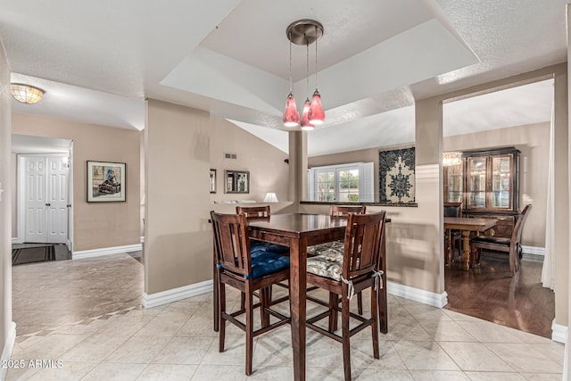 8219 E Morgan Trl, Scottsdale, AZ 85258 - dining area featuring light tile patterned floors and a tray ceiling