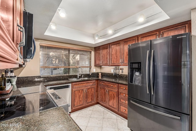 8219 E Morgan Trl, Scottsdale, AZ 85258 - kitchen with appliances with stainless steel finishes, a tray ceiling, brown cabinetry, and dark stone countertops
