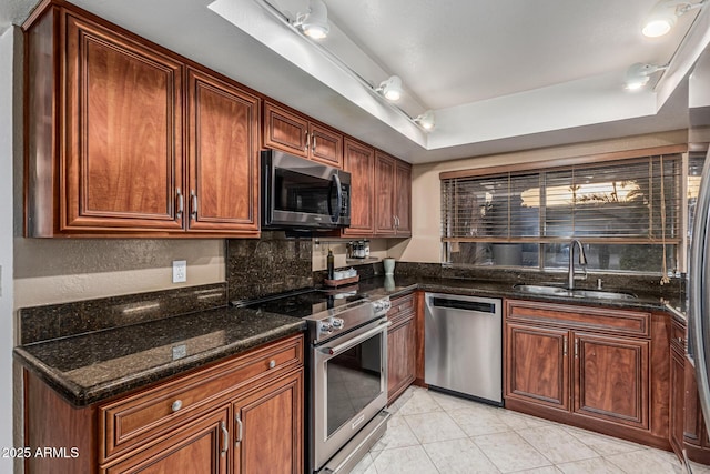 8219 E Morgan Trl, Scottsdale, AZ 85258 - kitchen with stainless steel appliances, dark stone counters, light tile patterned floors, and a raised ceiling