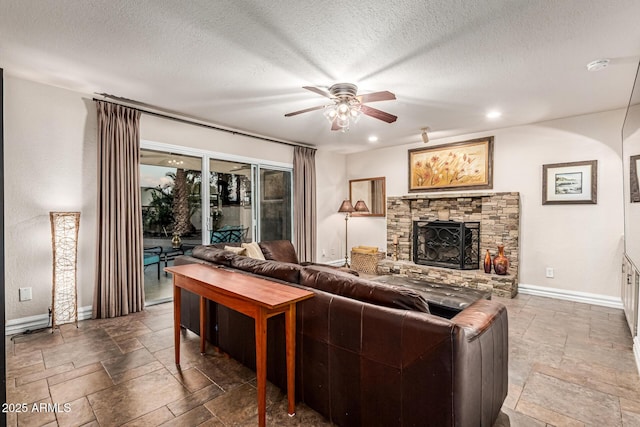 8219 E Morgan Trl, Scottsdale, AZ 85258 - living area featuring stone tile flooring, a ceiling fan, a fireplace, and a textured ceiling