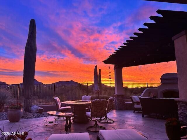 view of patio with fence and an outdoor living space with a fireplace