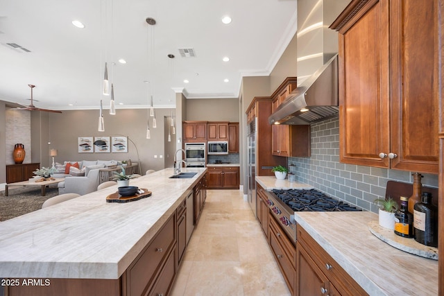 kitchen featuring built in appliances, visible vents, ornamental molding, wall chimney exhaust hood, and brown cabinetry