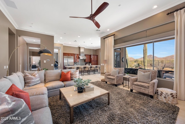 living area with ceiling fan, recessed lighting, a mountain view, and crown molding