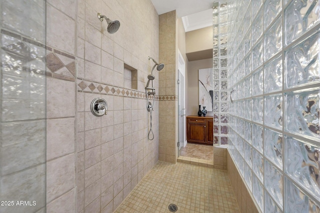 bathroom with ornamental molding and tiled shower