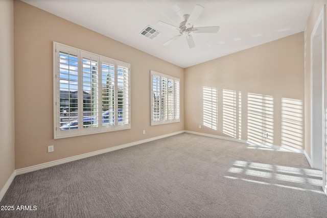 spare room with a ceiling fan, carpet, visible vents, and baseboards