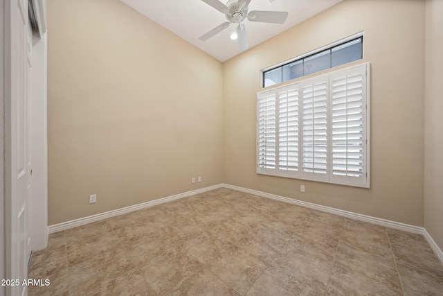 spare room featuring ceiling fan and baseboards