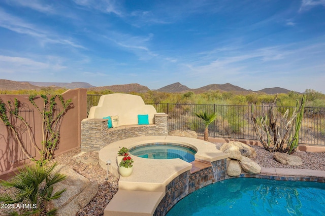 view of swimming pool with an in ground hot tub, a fenced backyard, a mountain view, and a fenced in pool