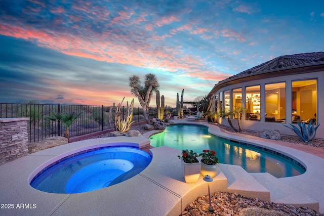 view of pool with a fenced backyard and a pool with connected hot tub