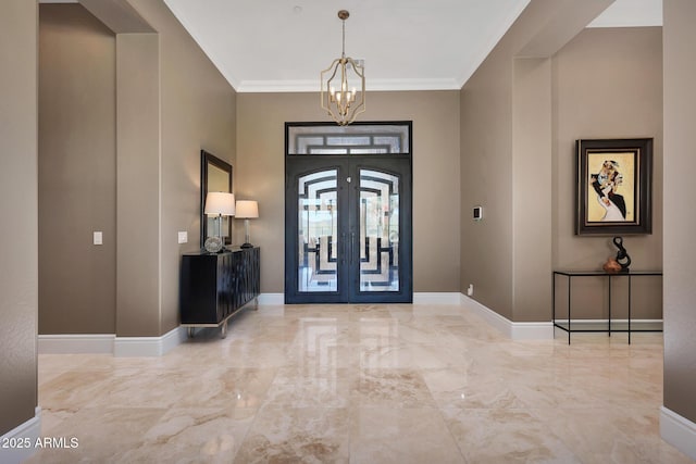 entrance foyer with baseboards, a chandelier, crown molding, and french doors