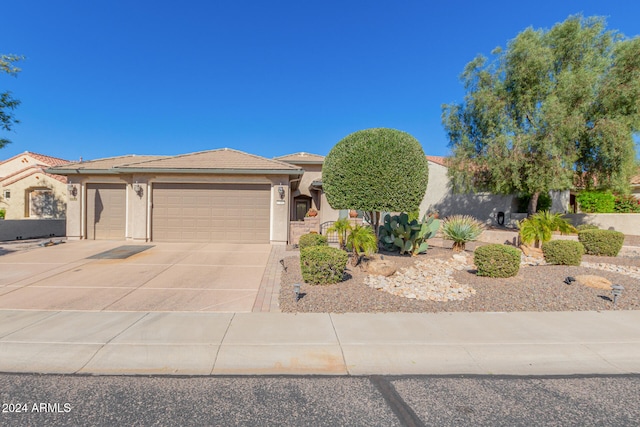 view of front of property with stucco siding, a tiled roof, concrete driveway, and a garage