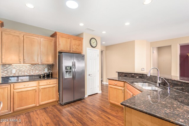 kitchen with a sink, tasteful backsplash, dark wood finished floors, recessed lighting, and stainless steel fridge