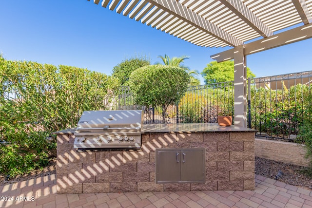 view of patio / terrace featuring area for grilling, exterior kitchen, a pergola, and fence