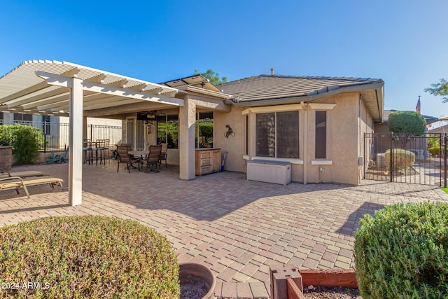 back of property with stucco siding, a pergola, a patio, and fence