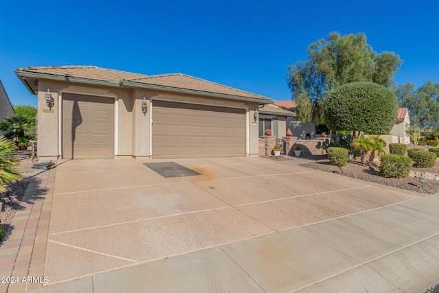 view of front facade featuring stucco siding, concrete driveway, an attached garage, and a tiled roof