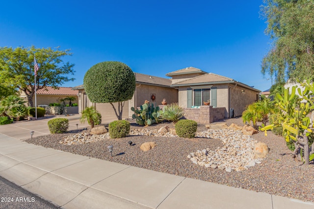 view of front of home featuring a tile roof, concrete driveway, a garage, and stucco siding