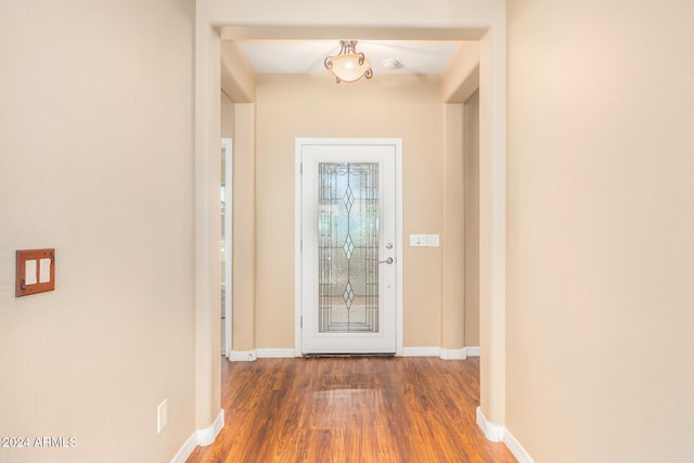 doorway with baseboards and wood finished floors