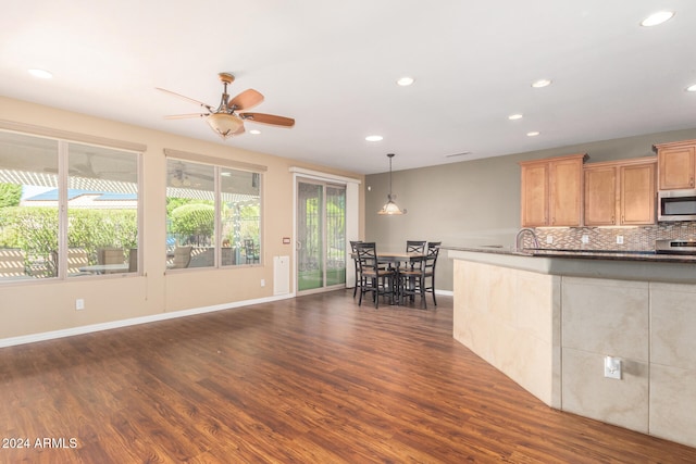 kitchen featuring tasteful backsplash, dark wood-style floors, recessed lighting, appliances with stainless steel finishes, and baseboards