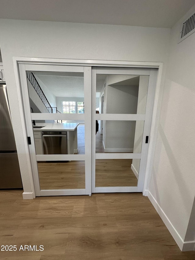 interior space featuring visible vents, baseboards, and wood finished floors