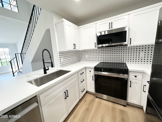 kitchen featuring a sink, appliances with stainless steel finishes, and light countertops