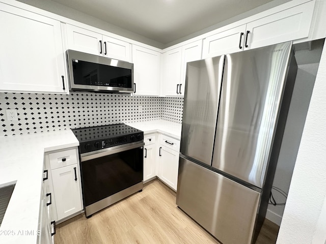 kitchen featuring light countertops, white cabinetry, appliances with stainless steel finishes, and light wood finished floors