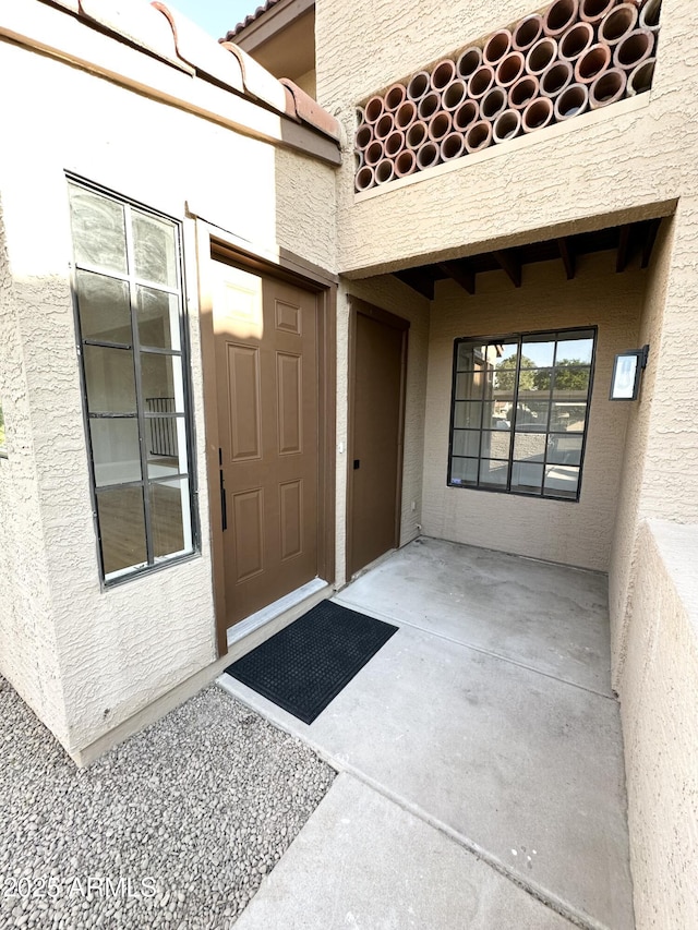 view of exterior entry with stucco siding